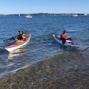 a group of people riding on the back of a boat in the water