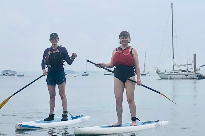 a group of people standing next to a body of water