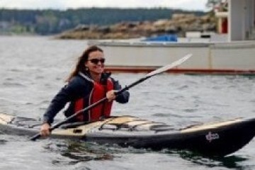 a person riding on the back of a boat in the water