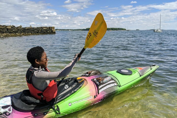 a man riding on the back of a boat in a body of water