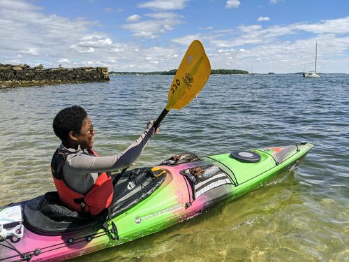 a man riding on the back of a boat in a body of water