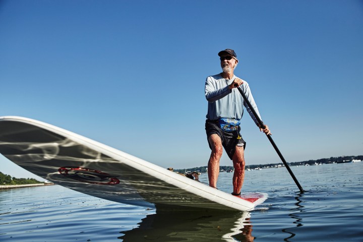 a man riding on the back of a boat in the water