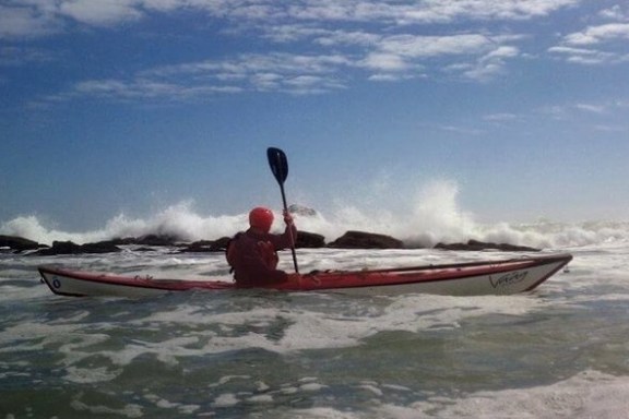A seakayaker with crashing waves in the background