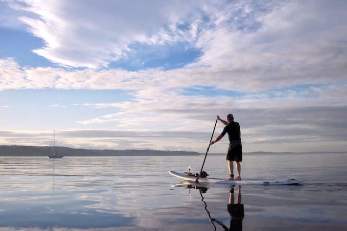 a man standing next to a body of water