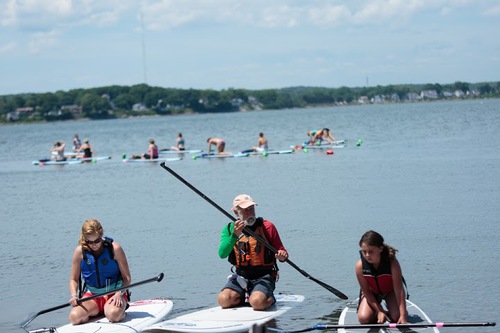 a group of people rowing a boat in a body of water