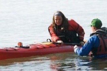 a person riding on the back of a boat in the water