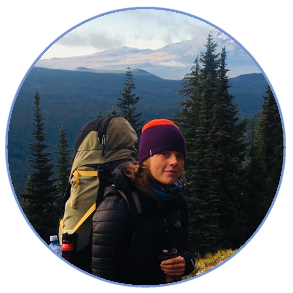 a woman on a mountain with a hiking pack on