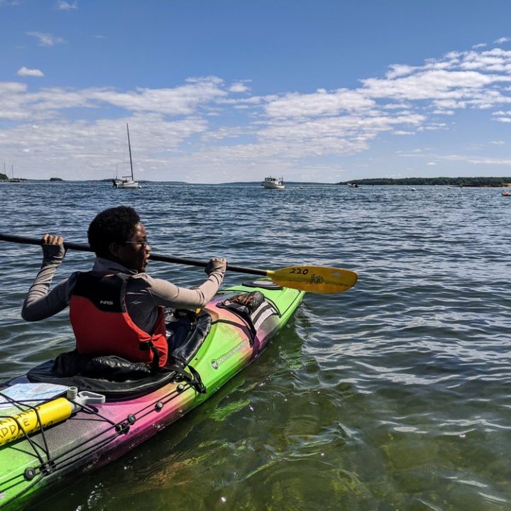a man riding on the back of a boat in a body of water
