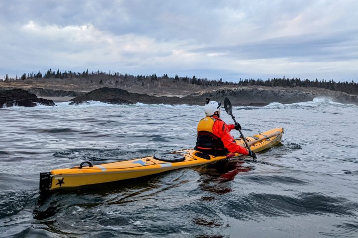 a man riding on the back of a boat in a body of water