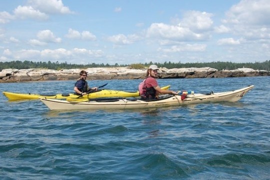 a group of people rowing a boat in the water