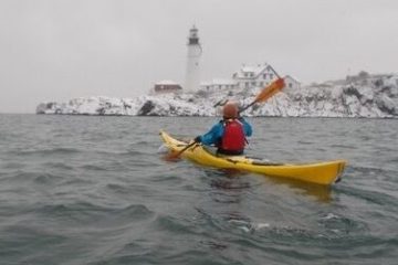 a person riding on the back of a boat in a body of water