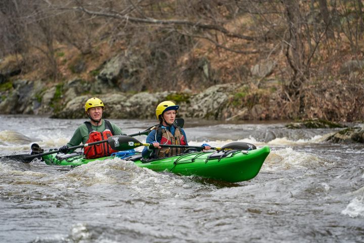 Tandem sea kayakers battle the currents of a whitewater river