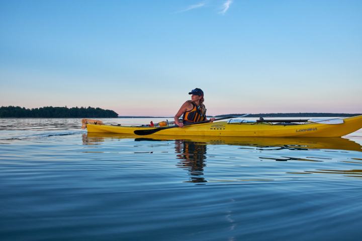 A woman sea kayaking on the coast of Maine