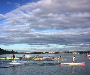 a group of people rowing a boat in a body of water