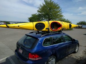 A kayak strapped to the roof of a car for transport