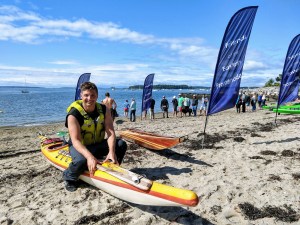 a person sitting on a beach holding a surfboard