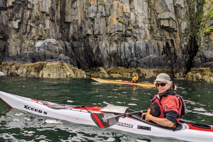 Suzanne in Seakayak below sea cliffs