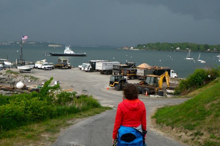 a person standing next to a body of water watching a thunderstorm