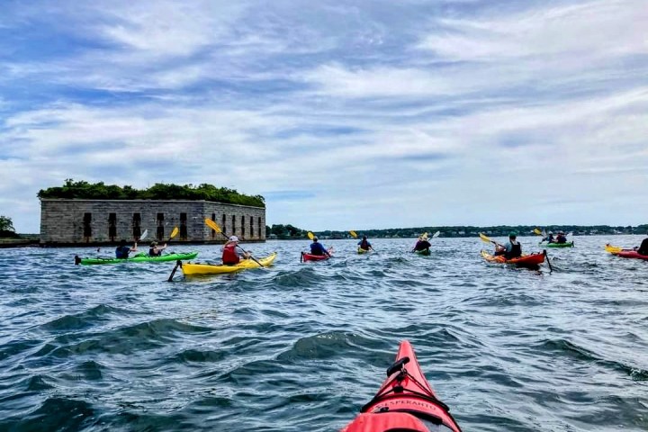 a group of people rowing a boat in the water