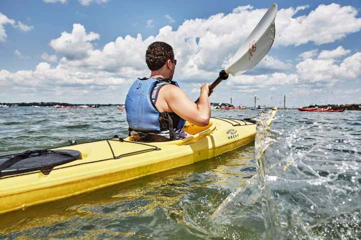 a man riding on the back of a boat in the water