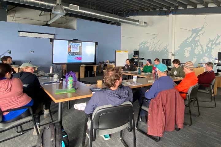 a group of people sitting at desks in a room