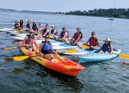A large group renting paddleboards and sit on top kayaks