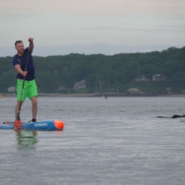 a person coming into the finish line on a paddleboard