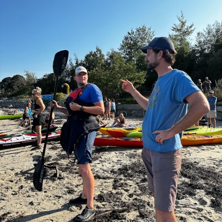 a group of people standing on top of a sandy beach