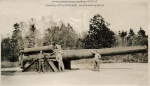 a vintage photo of three men standing in front of a large cannon