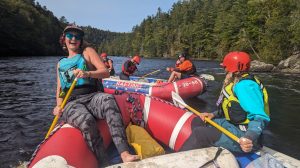 People sitting on rafts in a flat section of river