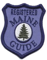 Purple shield patch with 'Registered Maine Guide' and a tree emblem.